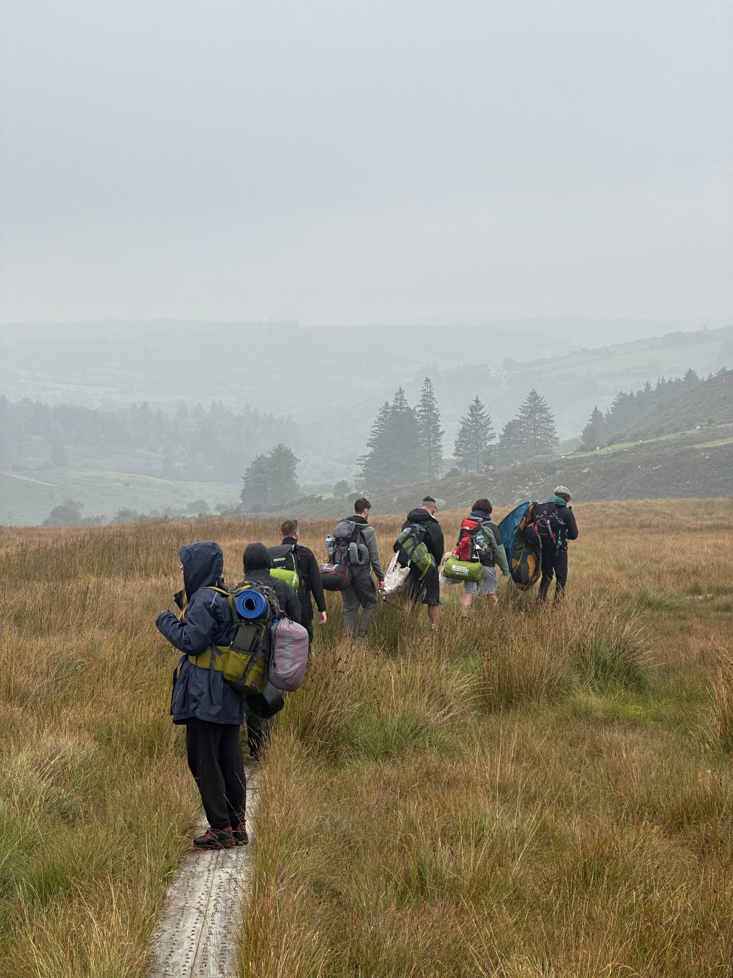 Hikers walking through misty moorland in the Comeragh Mountains